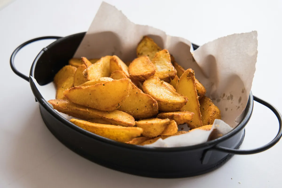 Vegetariska potatisklyftor i airfryer med krispig yta och mjuk insida.